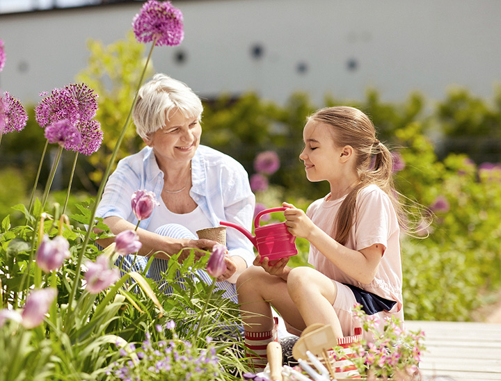 Image of grandparent and grandchild tending to a garden.